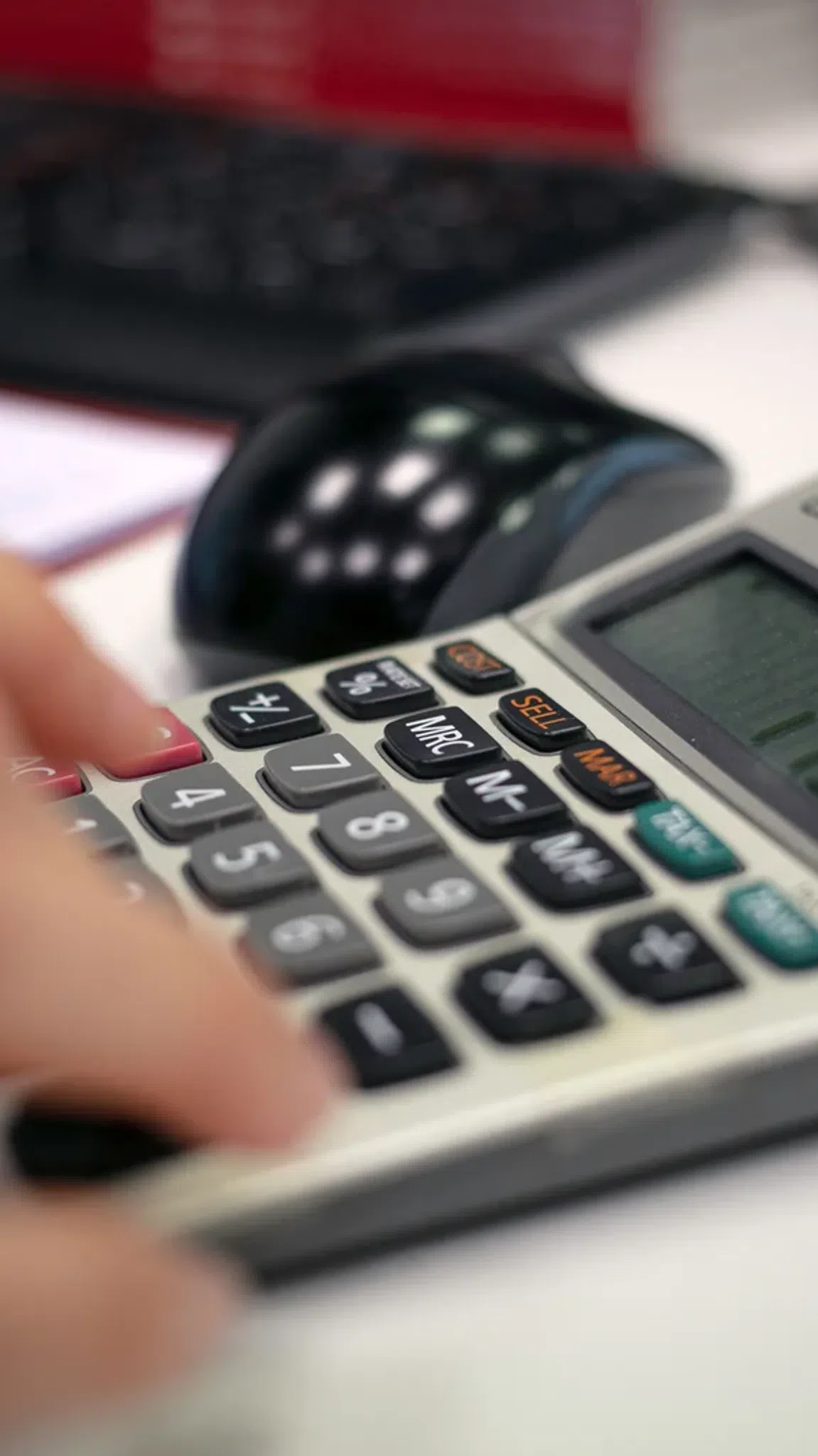 Persona revisando números y usando una calculadora, imagen relacionada con cuentas sin comisiones