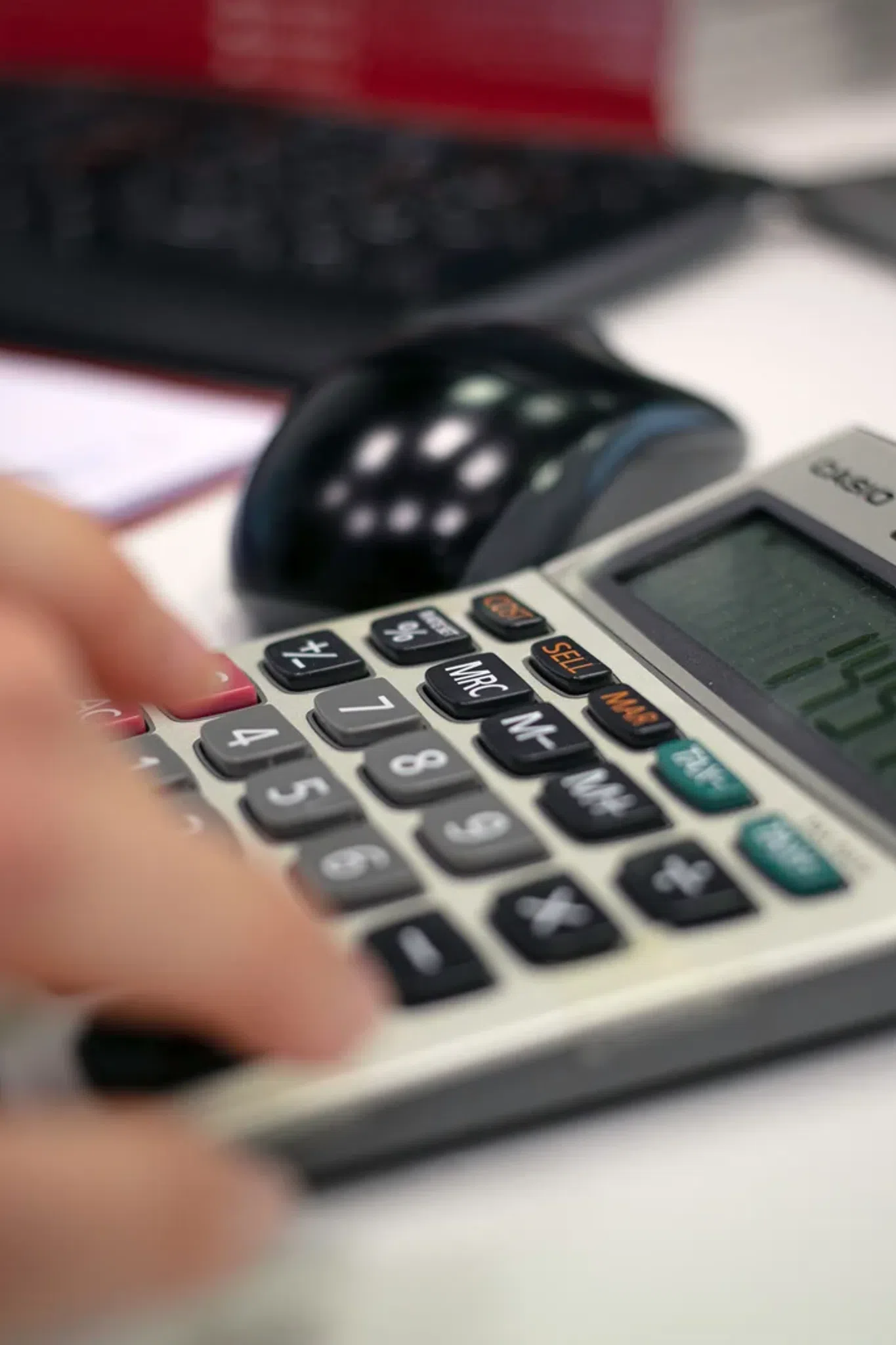 Persona revisando recibos y gastos junto a una calculadora